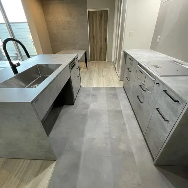 グレーを基調とした2列型のシステムキッチンと広い作業スペース